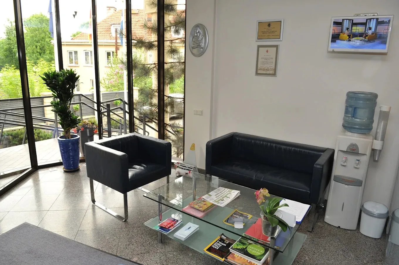 Klinikos laukiamasis su minkštais foteliais ir vaizdu į sodą